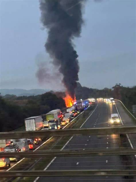 Thematic photo of a car fire on a road with emergency services present.