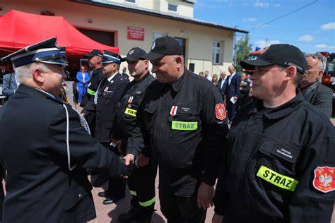 Zespołowe zdjęcie strażaków OSP Kryspinów przed remizą z wczesnych lat działalności