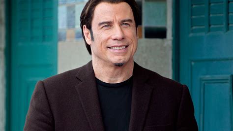John Travolta w mundurze strażaka rozmawiający przez radio, symbolizujący jego rolę mentora