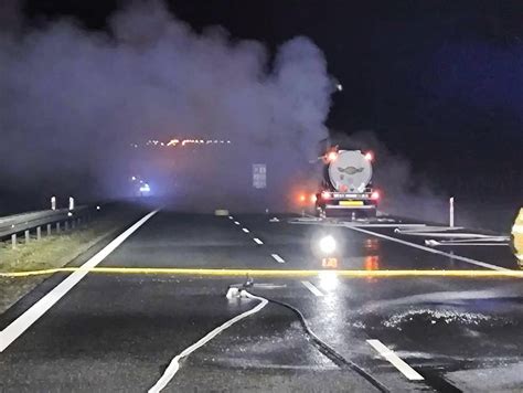Zdjęcie przedstawiające spaloną ciężarówkę na autostradzie A4, widoczne dym i działania strażaków