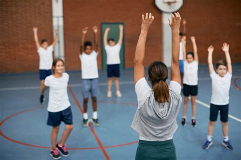 Zdjęcie nauczyciela wychowania fizycznego z młodzieżą podczas zajęć sportowych lub z piłką do siatkówki