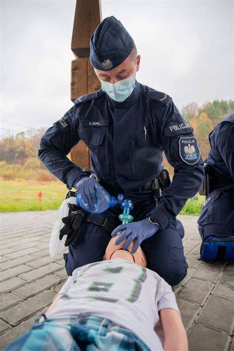 Policjanci udzielający pierwszej pomocy poszkodowanemu