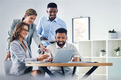 Zespół osób wspólnie pracujący nad kroniką, korzystający z laptopa, zdjęć i notatek