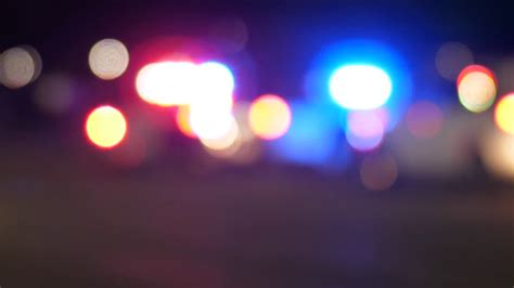 Thematic photo of a car accident scene with emergency vehicles (fire engine, police car) and flashing lights at night.
