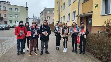 Wolontariusze WOŚP z puszkami na ulicach Białobrzegów, symbolizujący zaangażowanie lokalnej społeczności