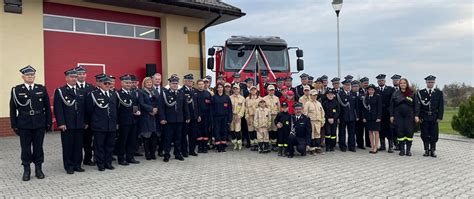 Grupa strażaków i gości podczas uroczystości przekazania nowego samochodu ratowniczo-gaśniczego