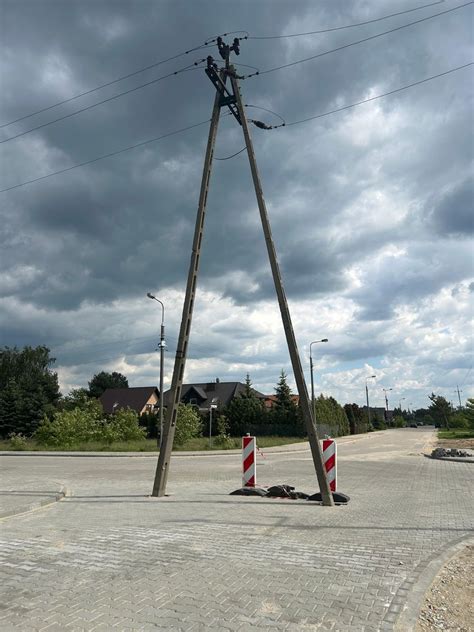 Zdjęcie rozbitego Volkswagena Touran uderzonego w słup energetyczny na tle wiaduktu kolejowego