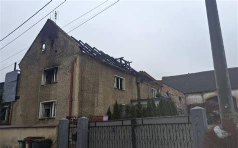 Fotografia przedstawiająca budynek z uszkodzonym poddaszem po pożarze