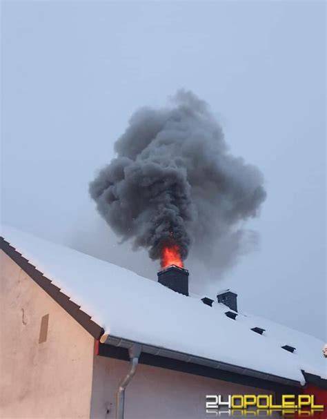 Strażacy gaszący płonącą sadzę w kominie i sprawdzający stan komina