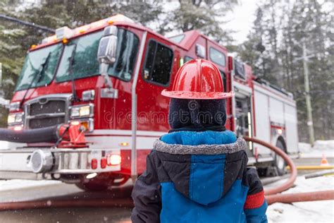 Thematic photo of a child looking at a fire truck or firefighters.