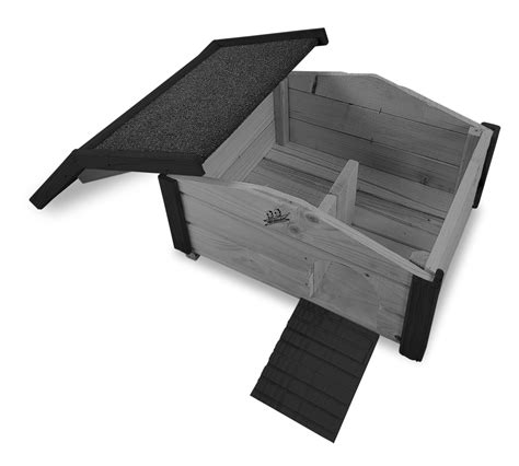 Zdjęcie naturalnego domku dla jeża wykonanego z drewna, umieszczonego w zielonym ogrodzie.