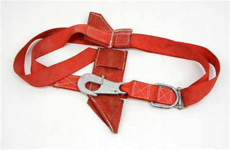 Zbliżenie na pas strażacki z przytroczonym multitool, kluczem serwisowym i latarką