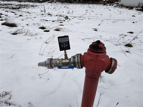 Zdjęcie technika wykonującego pomiar wydajności hydrantu