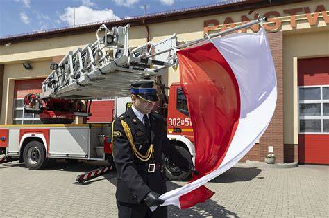 Zdjęcie strażaka w mundurze lub podczas akcji, z widocznym symbolem służby