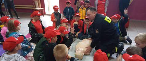 Zdjęcie dzieci z Akademii Małego Strażaka uczących się pierwszej pomocy