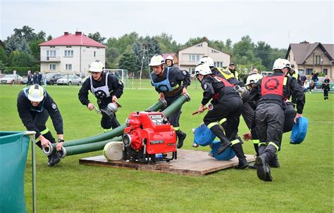 Zdjęcie grupowe strażaków OSP podczas zawodów sportowo-pożarniczych na boisku