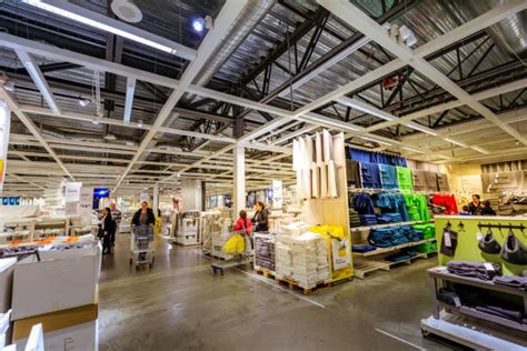Zdjęcie przedstawiające wnętrze sklepu IKEA, z widocznymi kasami samoobsługowymi lub magazynem
