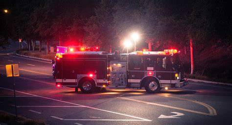 Thematic photo of a fire truck with active warning lights at an emergency scene