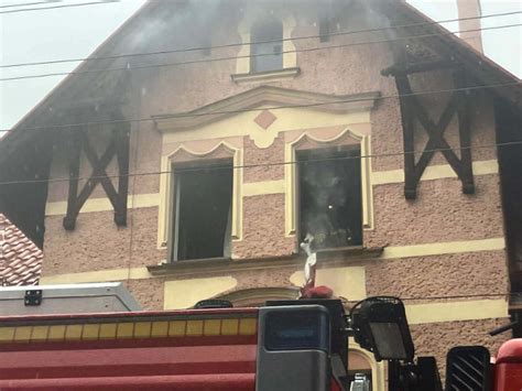 Strażacy gaszący pożar w budynku wielorodzinnym, dym wydobywający się z okien
