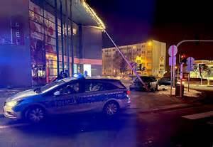Wypadek samochodowy w nocy, uszkodzony samochód i słup oświetleniowy