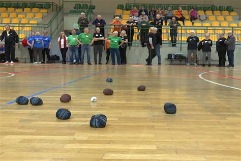 Zdjęcie z turnieju gry w boule lub rummikub, ukazujące uczestników w różnym wieku