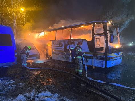 strażacy gaszący płonący bus w nocy