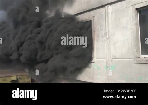 Thematic photo of a multi-story residential building with smoke coming out of a window on the second floor